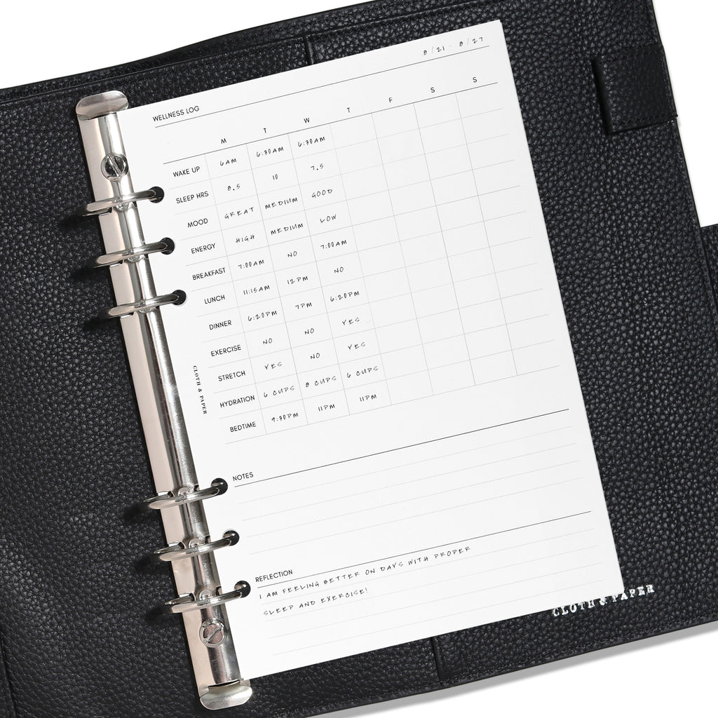 A5 Wellness Log insert displayed in a black leather planner. Demo page is shown. 
