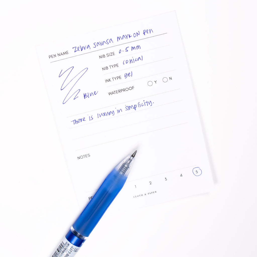 Blue pen displayed on top of a writing sample.