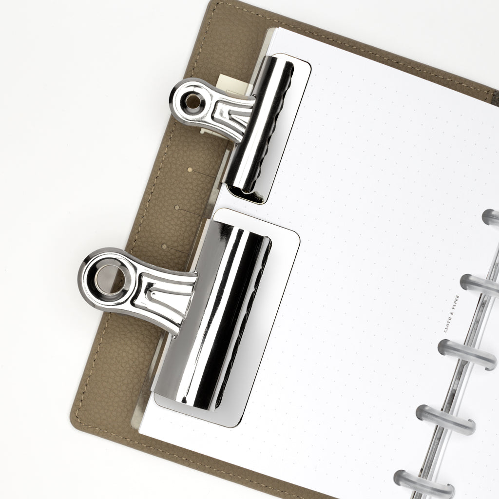 Small and large clips in use inside a discbound planner system.