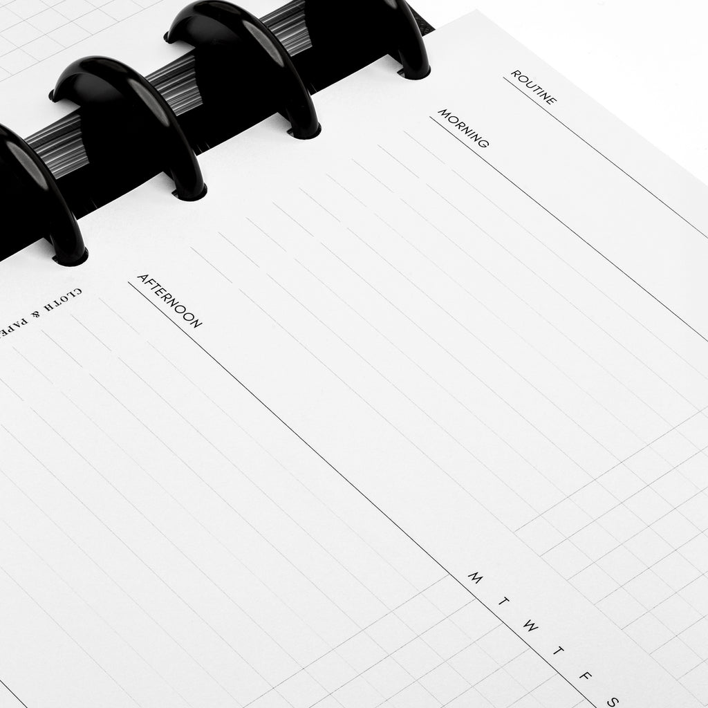 Closeup of insert in use inside a black discbound planner system. Focus is on the morning and afternoon sections of the routine section.