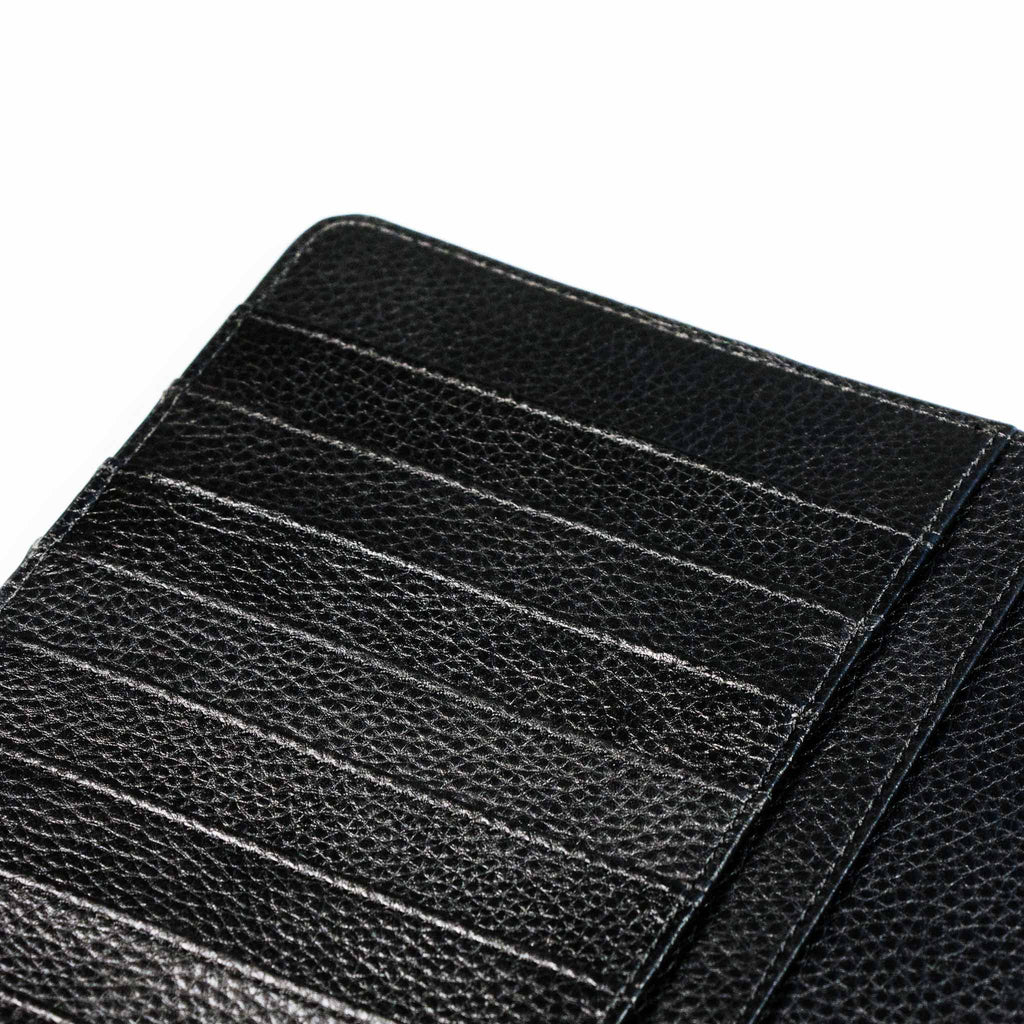 Close up on the credit card slots of a black agenda cover.