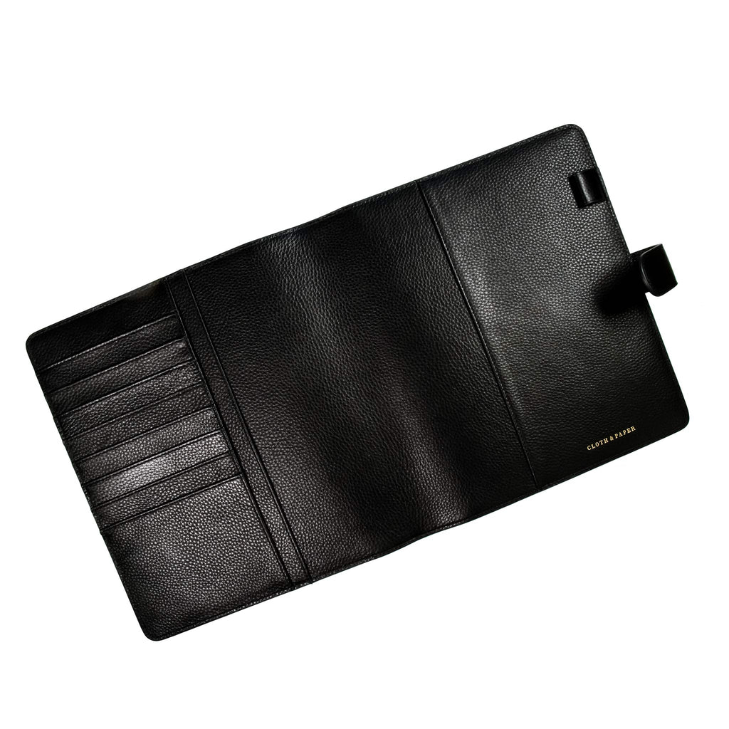 Black agenda cover opened to show inside. The document pockets, credit card slots, passport pocket, and pen loop on both sides are all shown.