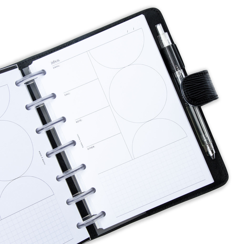 Insert in use inside of a discbound planner. The planner has clear discs and is tucked into a black leather cover. The cover has a clear pen in its pen loop.