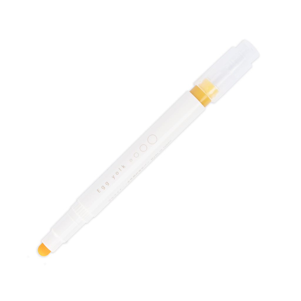 Egg Yolk highlighter with tip exposed and cap posted to the end of its barrel on a white background.