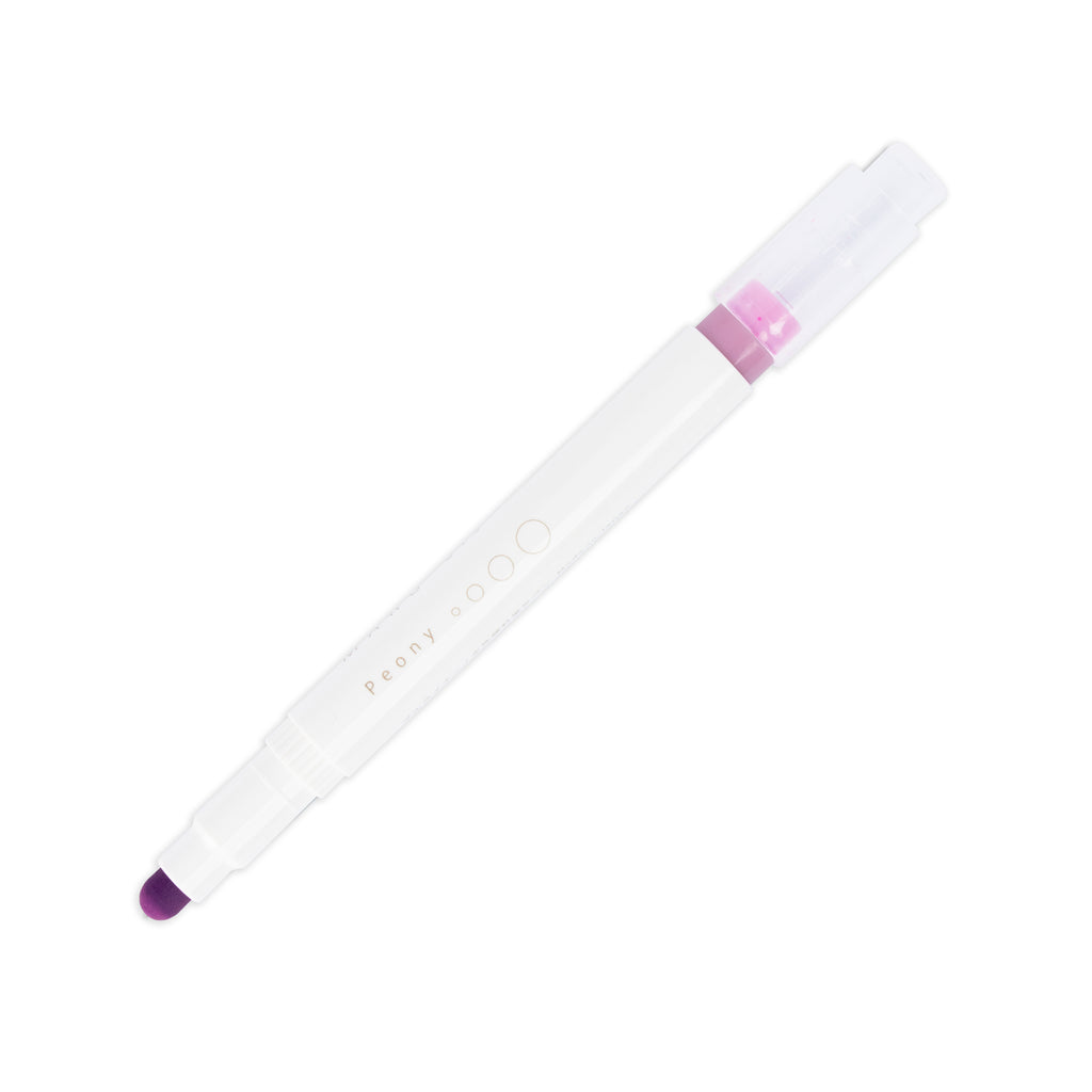 Peony highlighter with tip exposed and cap posted to the end of its barrel on a white background.