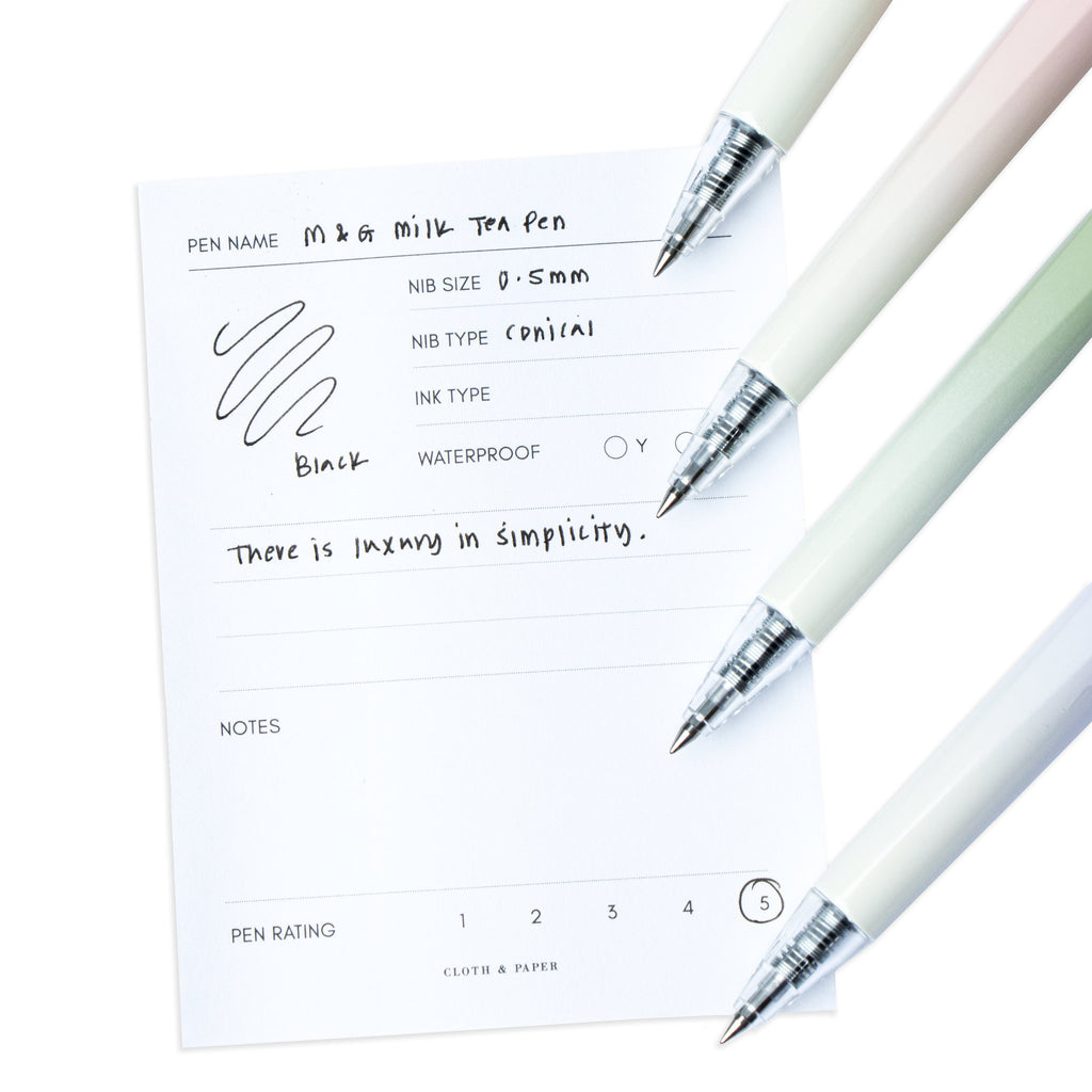 All four colors of the Milk Tea Pen resting on a pen test sheet displaying a writing sample detailing the pen's specs.