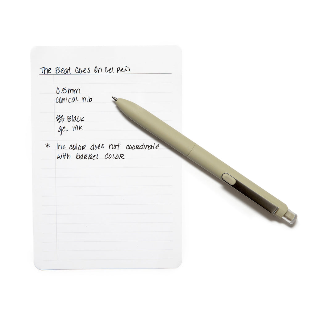 Pen in Olive resting on a piece of paper with a writing sample detailing pen specs.