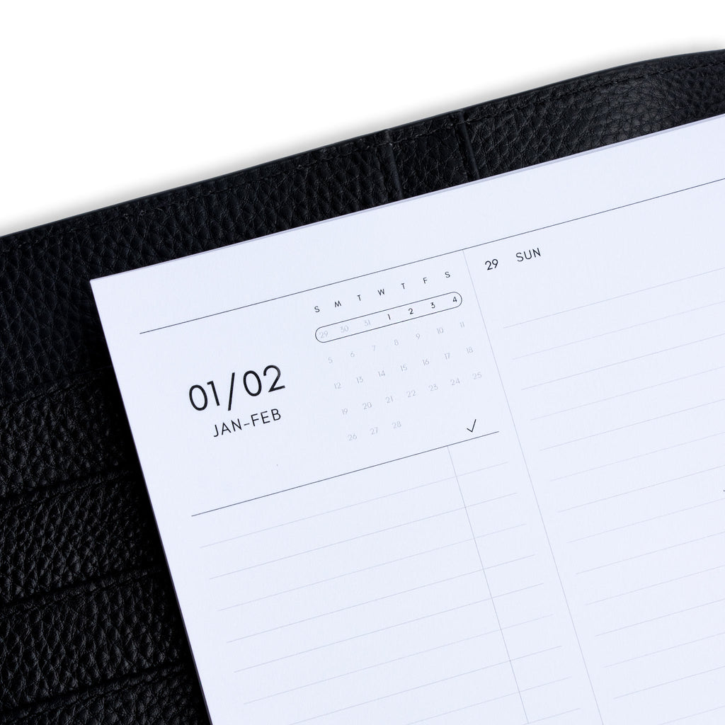 2023 Dated Planner Inserts, Vertical Weekly Lined, Sunday Start, Cloth and Paper. Close up image of inserts in use inside a black leather agenda.