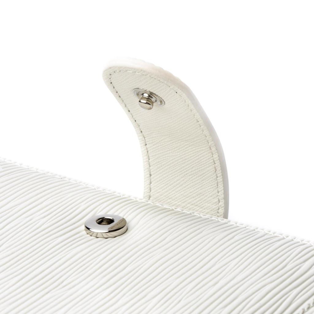 Close up on the snap closure detail on a white agenda with silver snap hardware.