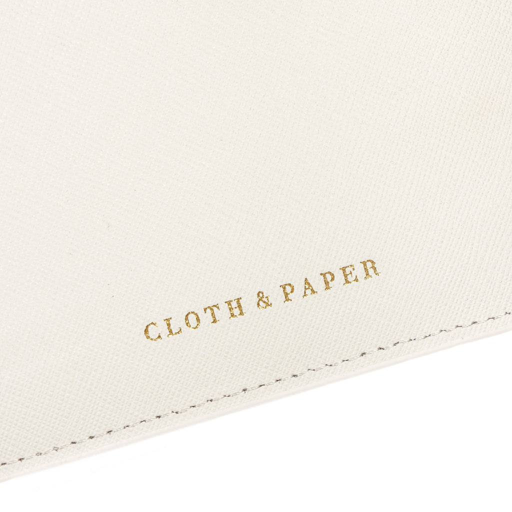 Close up on the gold Cloth and Paper logo stamp on the inside of a white agenda.