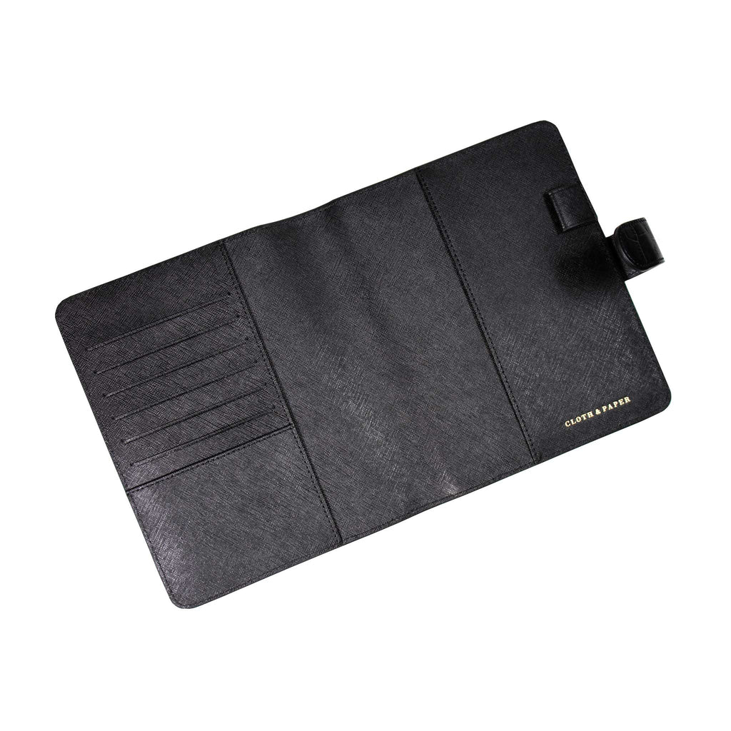 Black agenda cover opened to show the inside. The document pockets, credit card slots, passport pocket, and pen loop are all shown.
