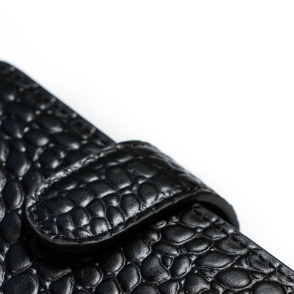 Close up on the crocodile-style leather detail on a black agenda.