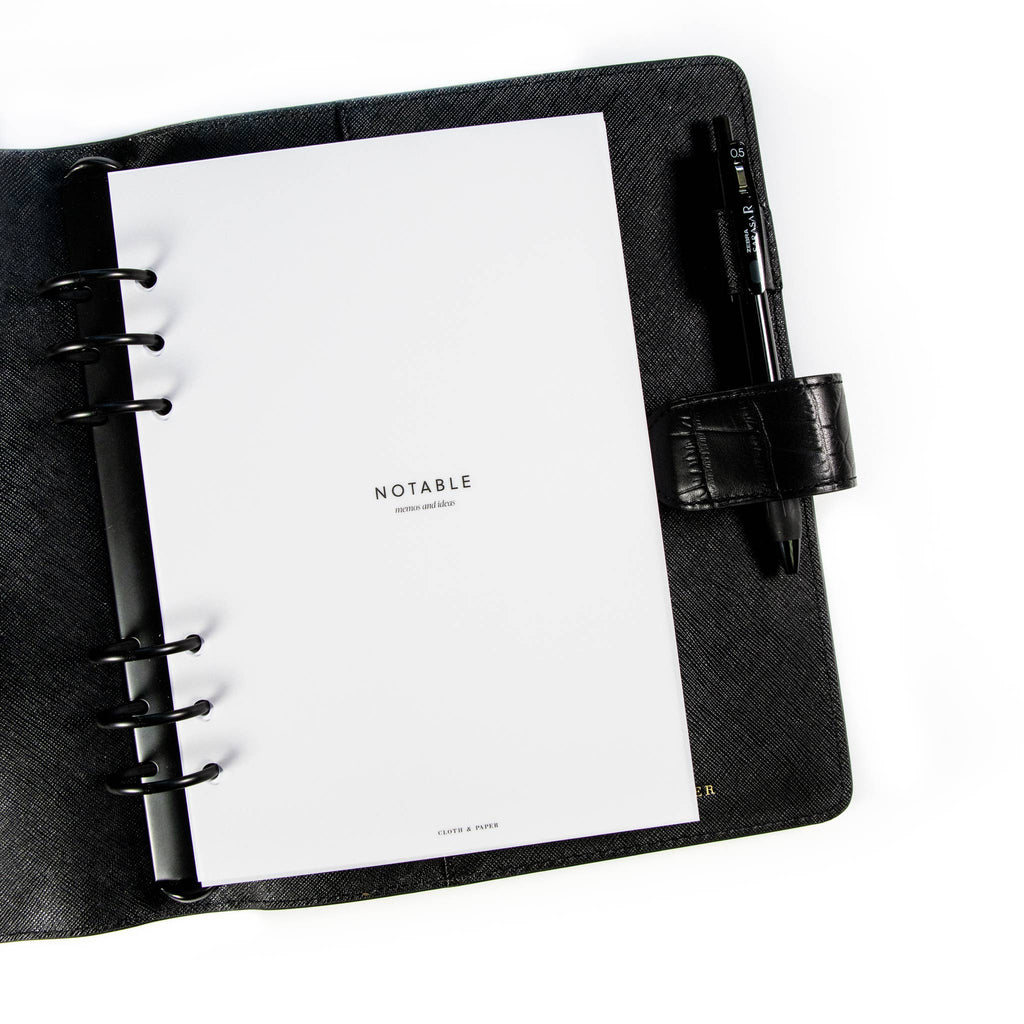 Notable Section Cover Planner Dashboard styled inside a black leather agenda. The agenda has a black pen tucked into its pen loop.