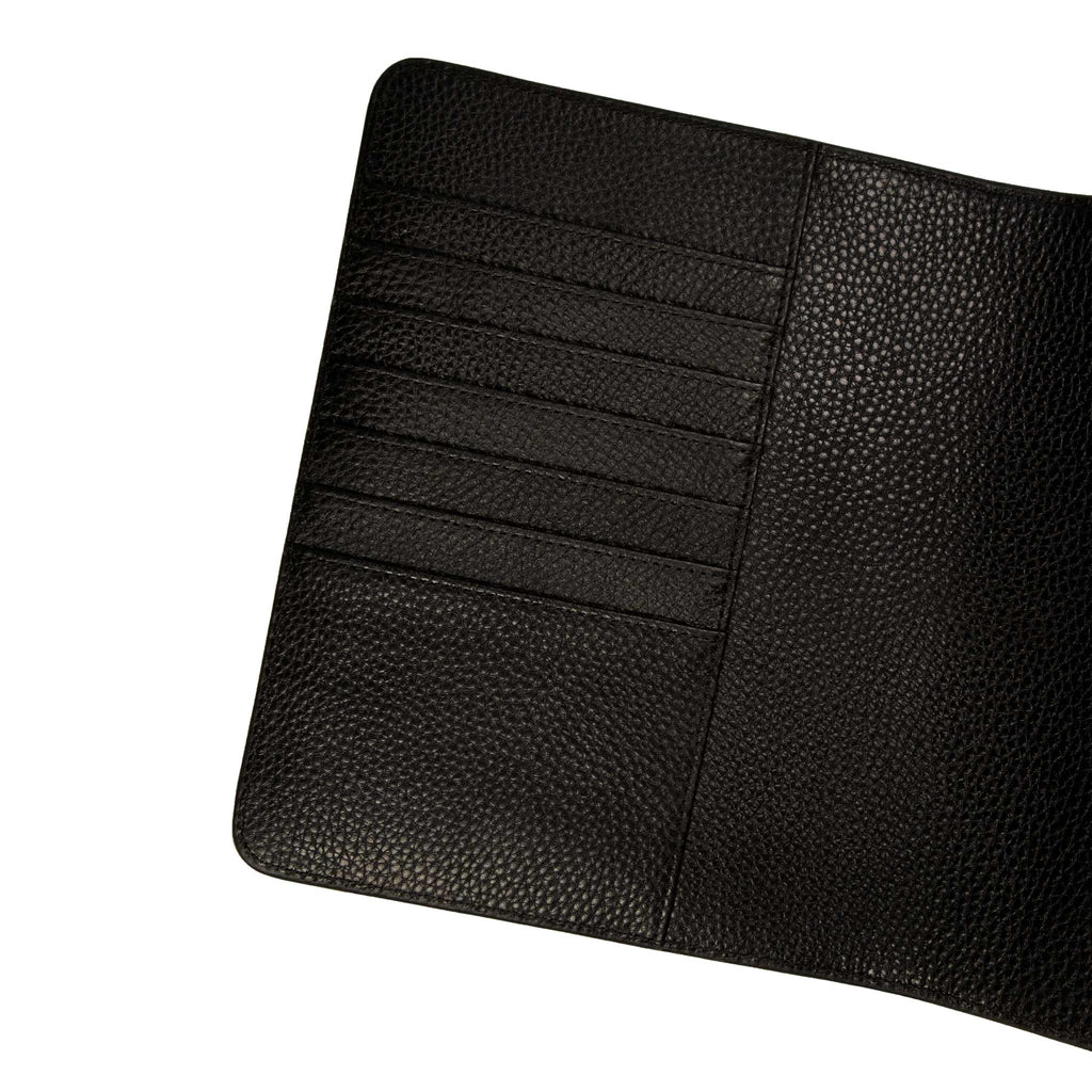 Close up on the inside cover of a black leather agenda. The document pocket, credit card slots, and passport pocket are shown.