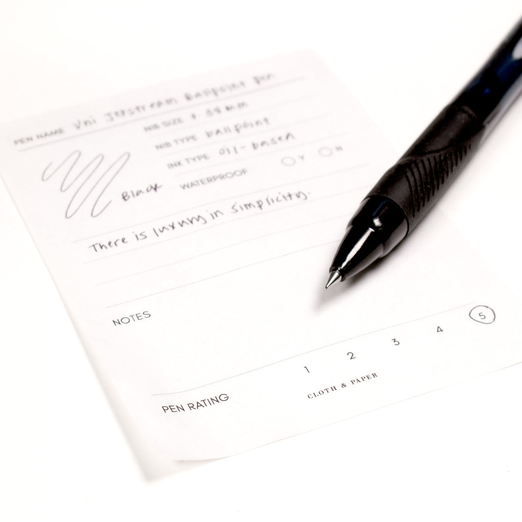 Uni Jetstream Ballpoint Pen, 0.38 mm, Black, Cloth and Paper. Close up on pen nib resting on pen test sheet.