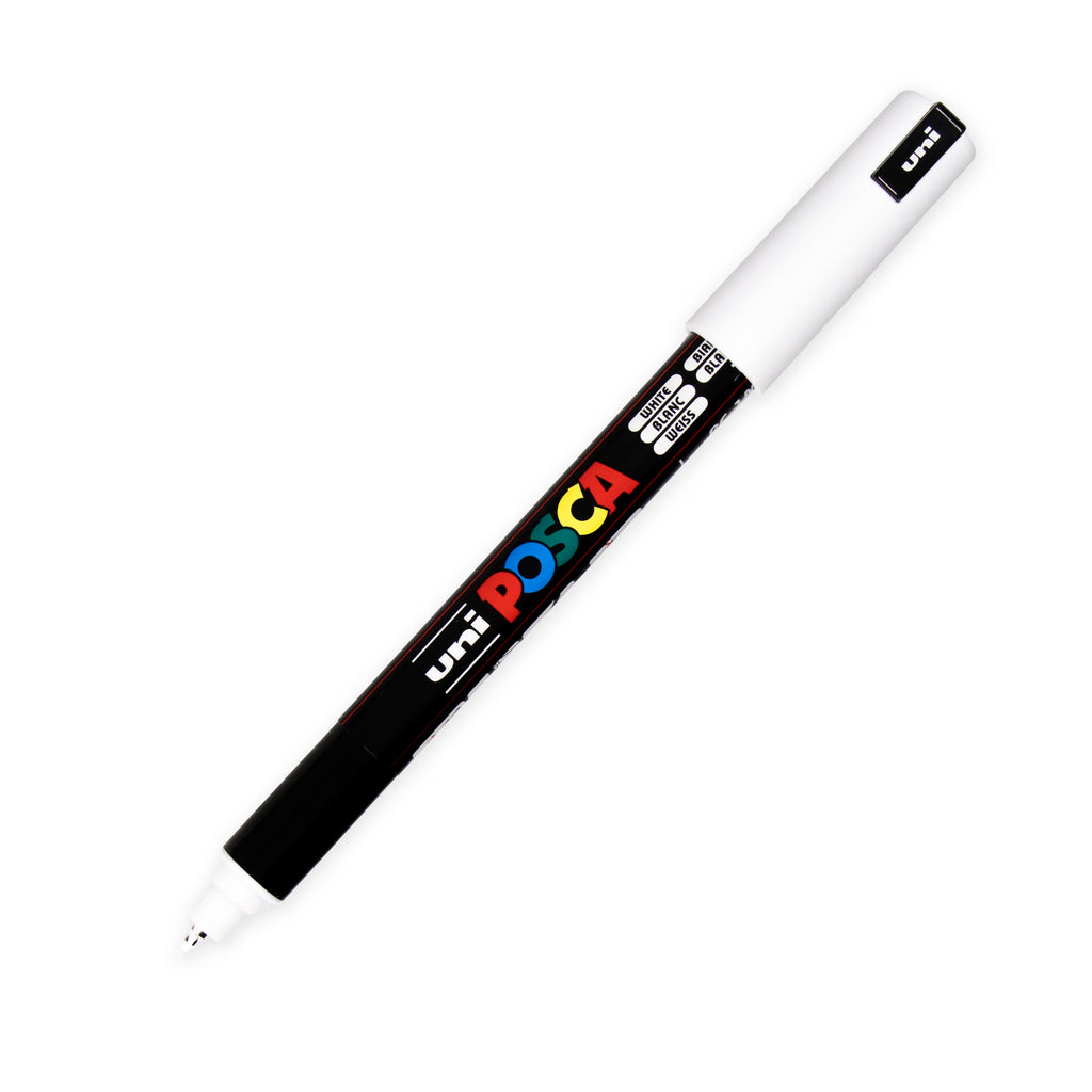 Uni Posca Paint Marker, Ultra Fine Point, White, Cloth and Paper. Uncapped marker with cap posted turned to the right against a white background.