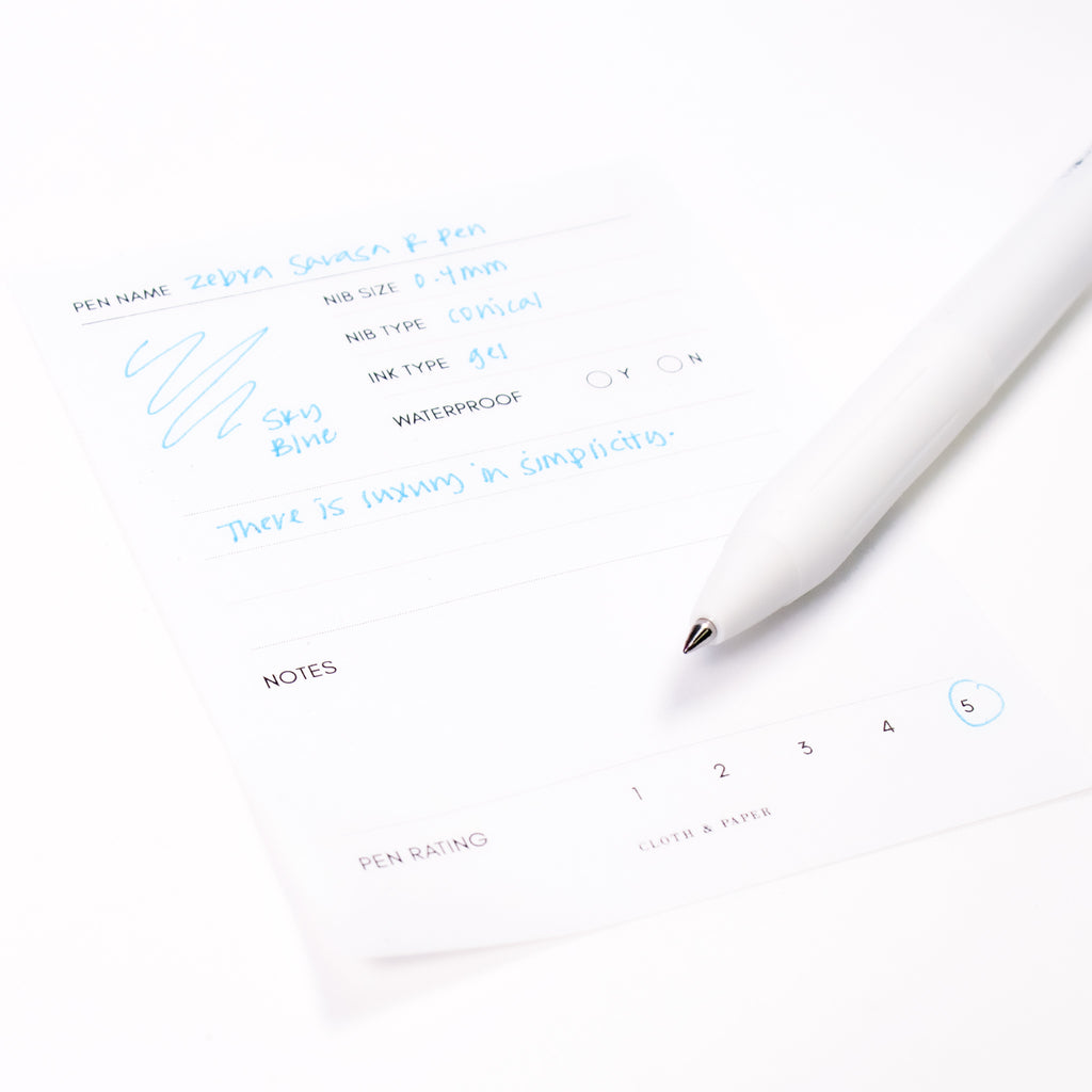 Zebra Sarasa R Pen, 0.4 mm, Sky Blue, Cloth and Paper. Pen resting on pen test sheet displaying writing sample.