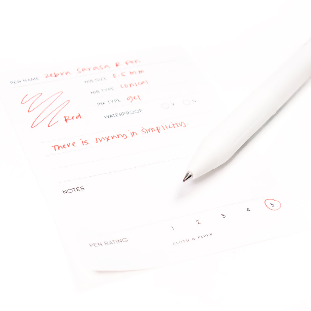 Zebra Sarasa R Pen, 0.5 mm, Red, Cloth and Paper. Close up on pen nib resting on pen test sheet.